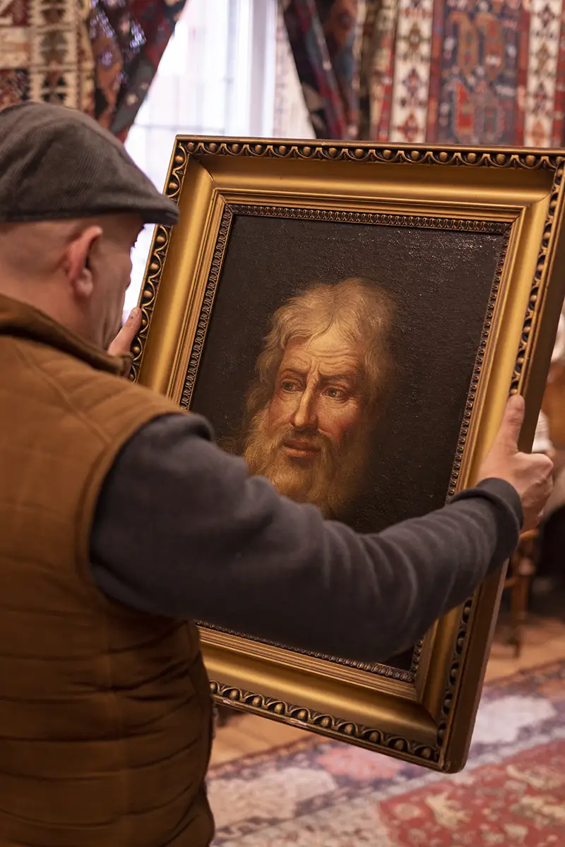 Varga István, régiségkereskedő és műgyűjtő festményt vizsgál